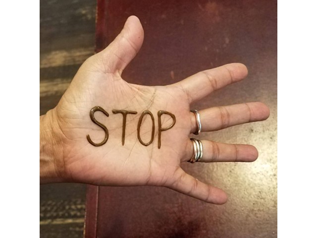 Word 'stop" tattooed on hand